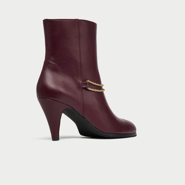 Maya cherry leather boot with gold chain detail on a white background 