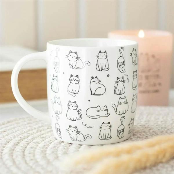 White ceramic mug with happy cat line-print pattern, curved handle on left side