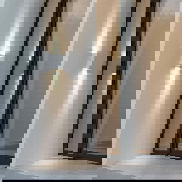 white up and down outside wall light mounted on the wall next to the door of a modern home