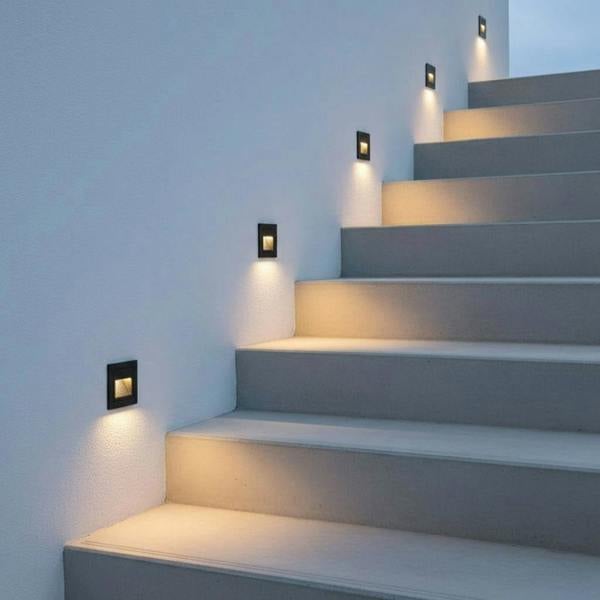 black outdoor stair step lighting fitted on the wall next to some outdoor steps 