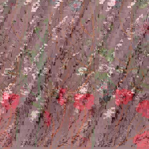 Embroidered floral pattern on a fabric with red, pink, and green flowers on a pink background.