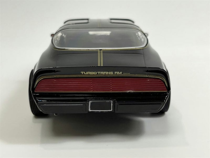 a black toy car with a red stripe