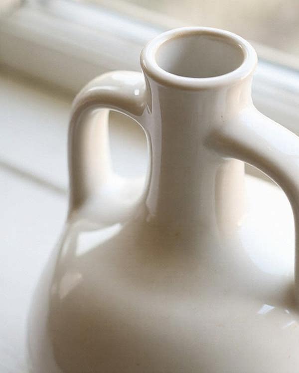 White ceramic vase on a windowsill with natural light