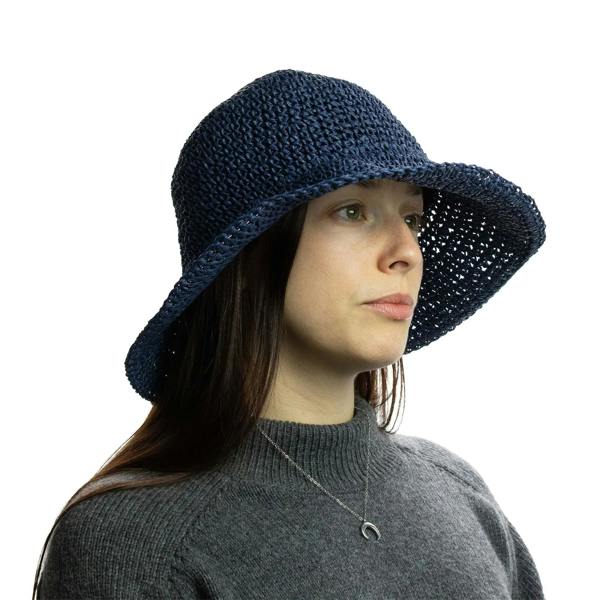 Navy blue floppy straw sun hat worn by model with chin-length brim