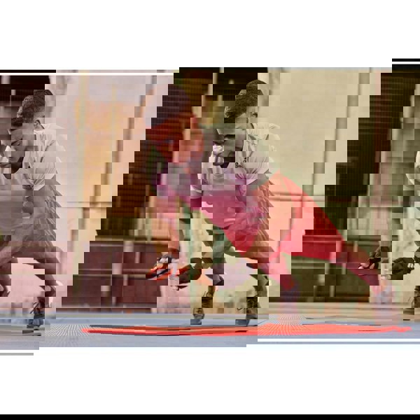 Man in athletic wear performing push-ups on a mat outdoors with the adidas weighted gloves