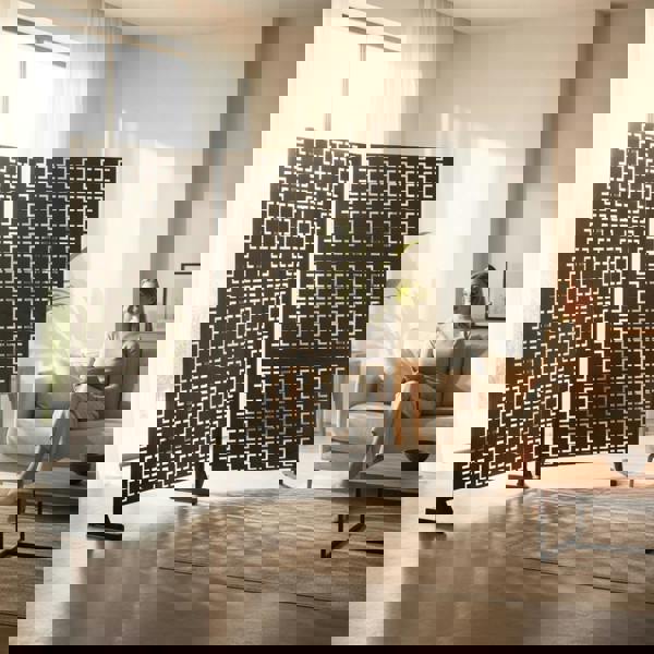 A person sitting on a couch in a living room with a privacy screen.