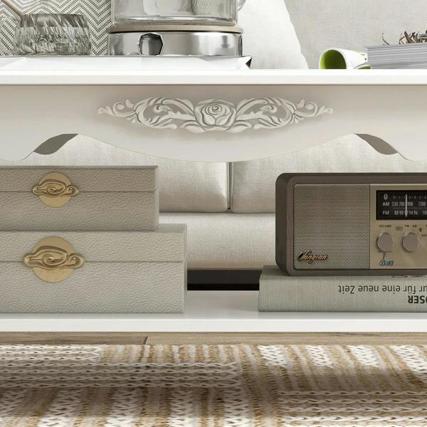 Close-up of white coffee table drawers with ornate apron and gold-style handles