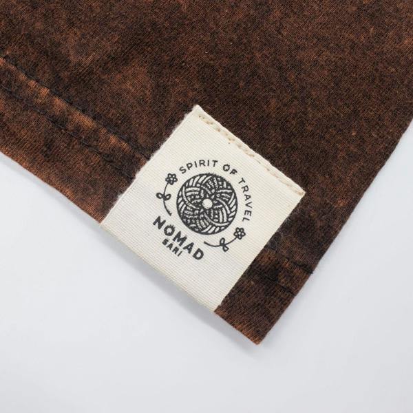Brown T-shirt cuff with Spirit of Travel woven label