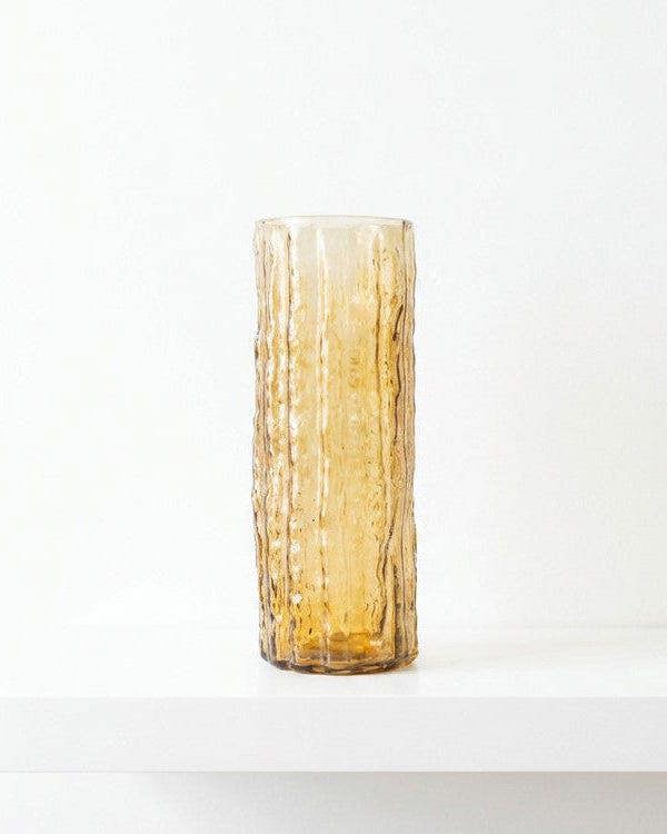 Decorative vase with white flowers against a wooden background
