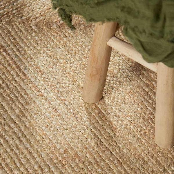 Close-up of a woven mat with a wooden stool on top, featuring natural textures.