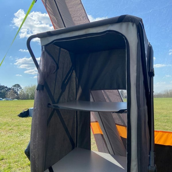 An image of the Collapsible Camp Storage Cupboard from OLPRO in a campervan awning pitched on a campsite.