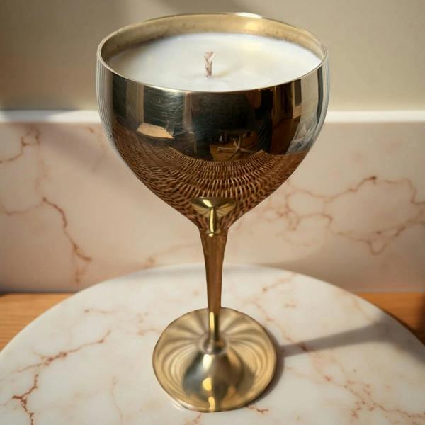 Gold candle holder with a candle on a marble surface