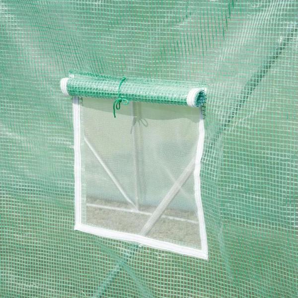 Green roll-up mesh window panel with white support bar on greenhouse wall