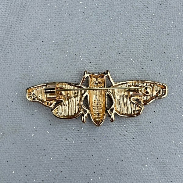 Gold moth brooch, textured metal finish, outstretched wing design, secure pin fastening, vintage inspired jewellery, nature themed accessory, unique statement brooch, elegant gift for her
