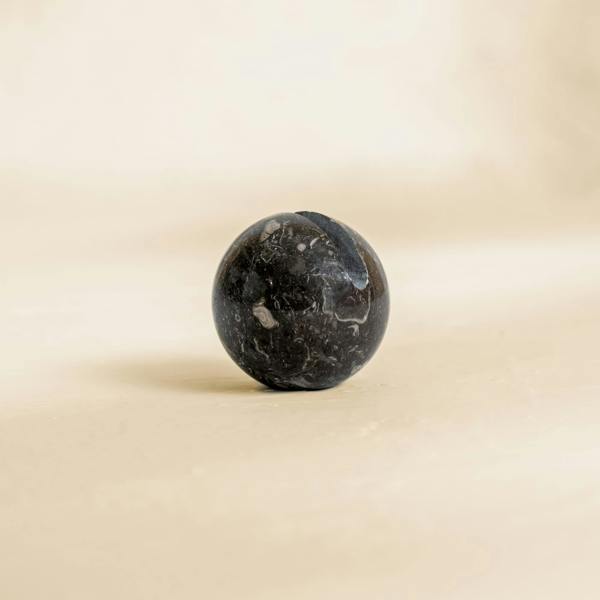 Black marble ball on a beige background cable organisation 