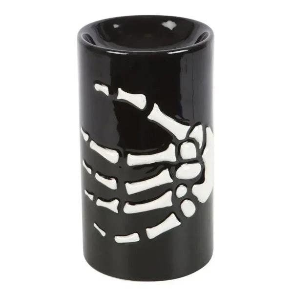 Black skeleton hand oil burner with white bone cutout design, cylindrical tealight holder