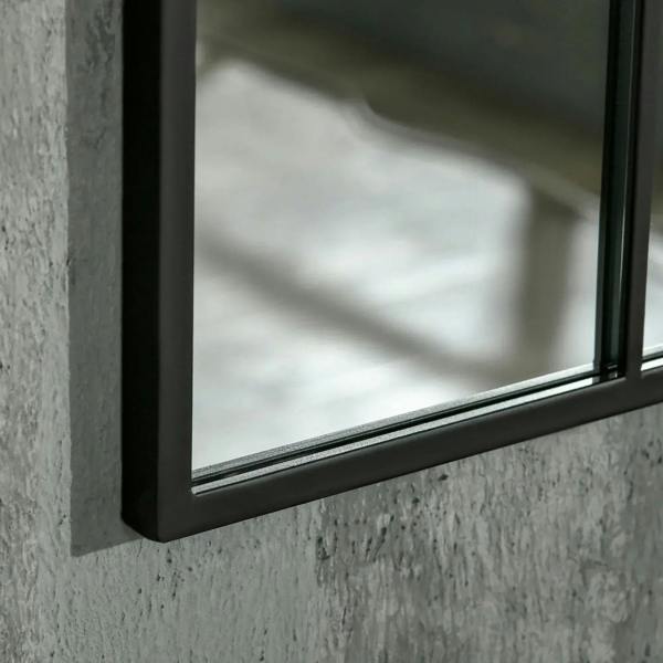 Close-up of arched grid mirror frame edge with black trim and reflective glass.
