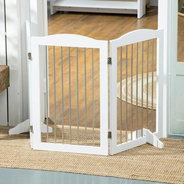 White freestanding dog gate set at doorway with vertical bars and side support feet
