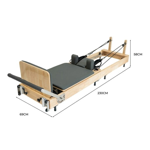 Oak Pilates reformer machine with a padded gray platform, adjustable straps, and a sleek, sturdy design for versatile workouts