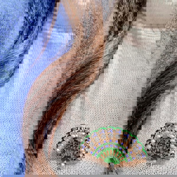 green brooch with pearls wedding guest