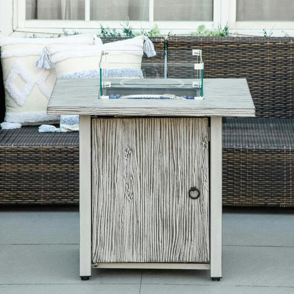 Grey gas fire pit table with glass screen on top and closed front door panel