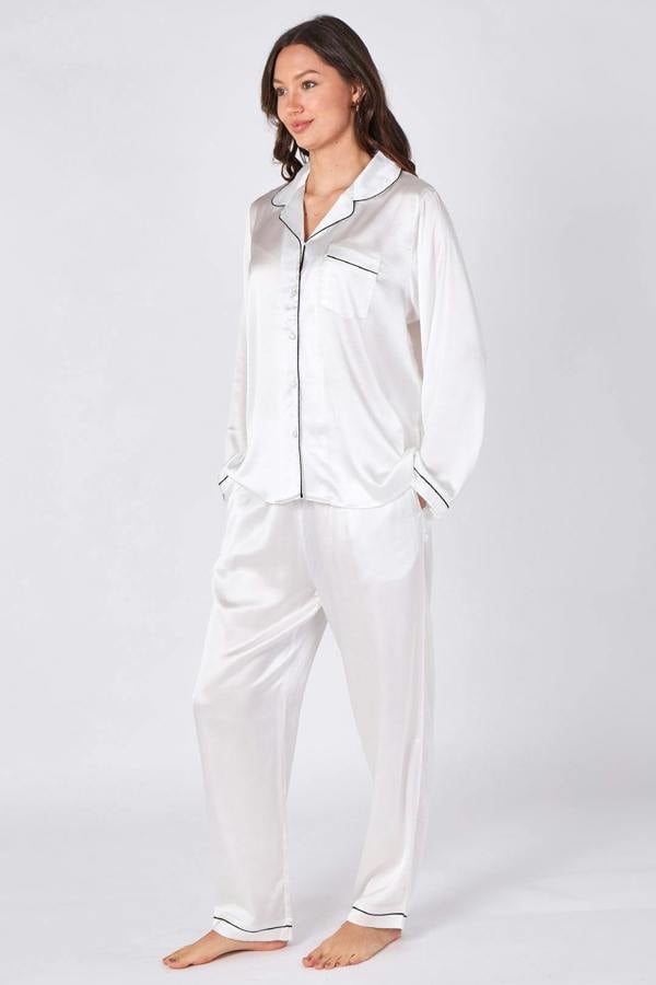 Woman wearing white satin pajamas on a white background