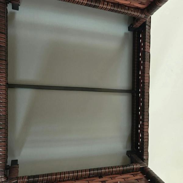 Close-up of brown woven rattan side table frame corner with metal brace