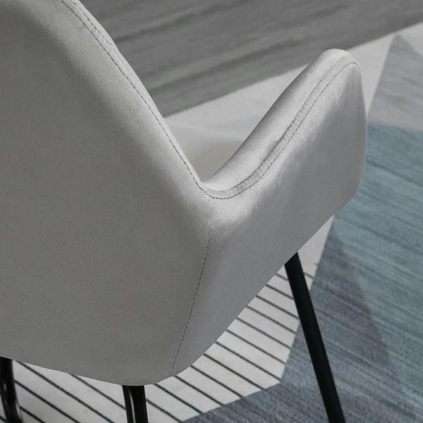 Grey upholstered arm chair with curved side panel, channel back, and black metal legs
