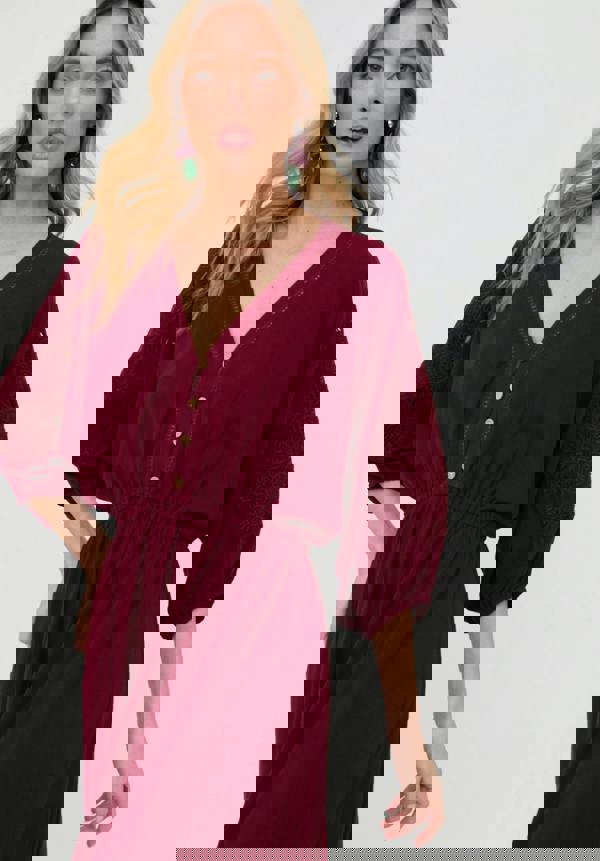 Woman wearing a burgundy dress with a plain background