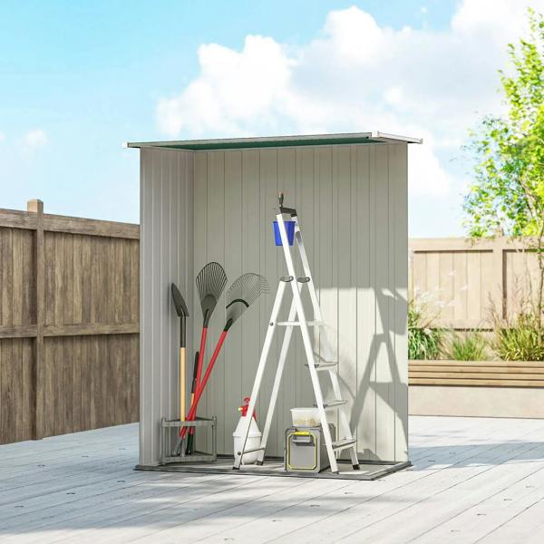 Green metal storage shed with closed door and tools leaning inside