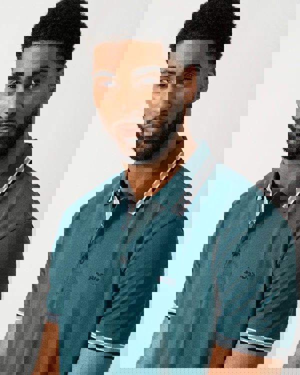 detail shot of a model wearing a BOSS Green Paddy Mens Cotton-Piqué Polo Shirt with Contrast Logo in Open Green