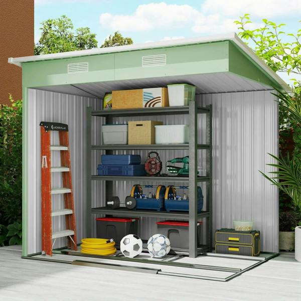 Light green metal storage shed with shelving inside and open double sliding doors