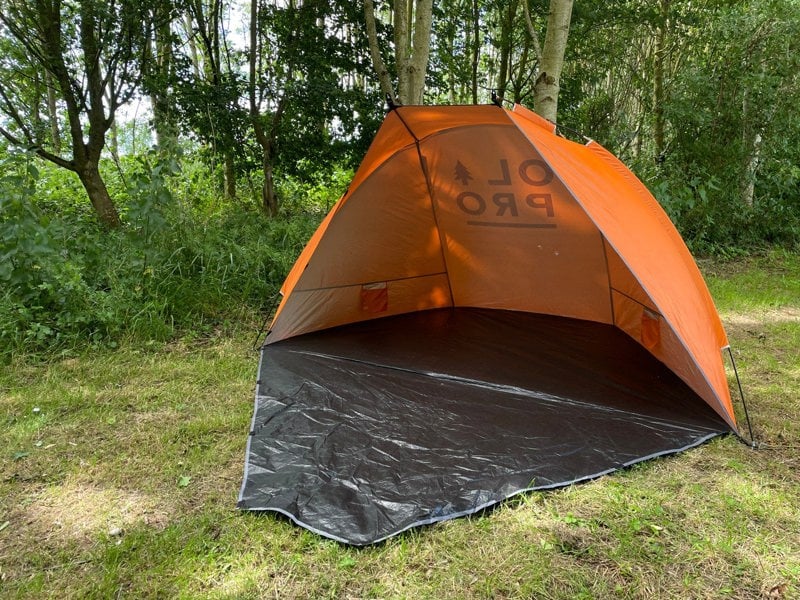 An image of the Beach Tent from OLPRO in front of a treeline on a campsite.
