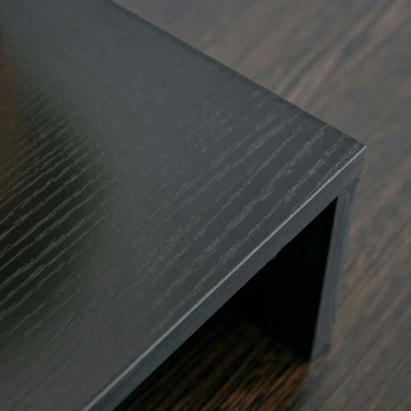 Black monitor stand riser edge detail with textured grain finish