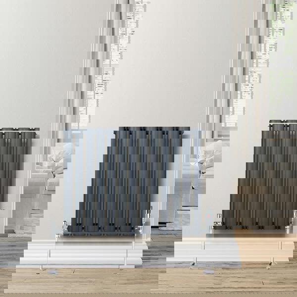 Anthracite grey oval single column radiator, 600 x 780mm, featuring vertical bars and chrome valves, mounted on a light wall