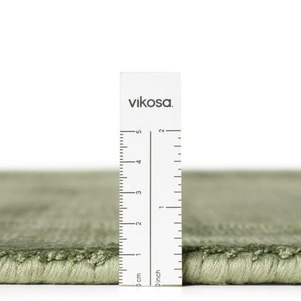 Green rug with a ruler and 'vikosa' branding on a white background