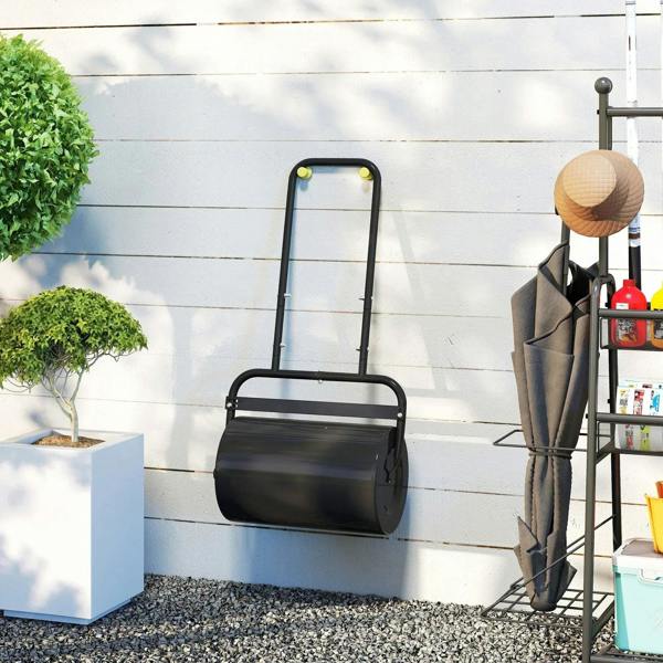 Black lawn roller with upright handle frame and wide cylinder against a wall