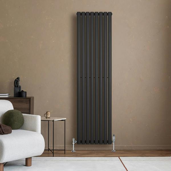 Sleek black oval single column radiator mounted on a textured wall, paired with stylish valves, enhancing modern interior decor
