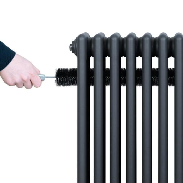 Traditional anthracite 4 column radiator, 300 x 1010mm, with a hand cleaning it using a brush, showcasing its sleek design and finish