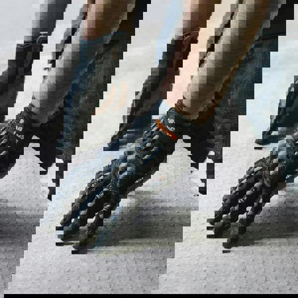 Scruffs Trade Shock Impact Mens Work Padded Palm Gloves, close-up of a person wearing black gloves with padded palms and fingers, suitable for heavy-duty work and impact protection.