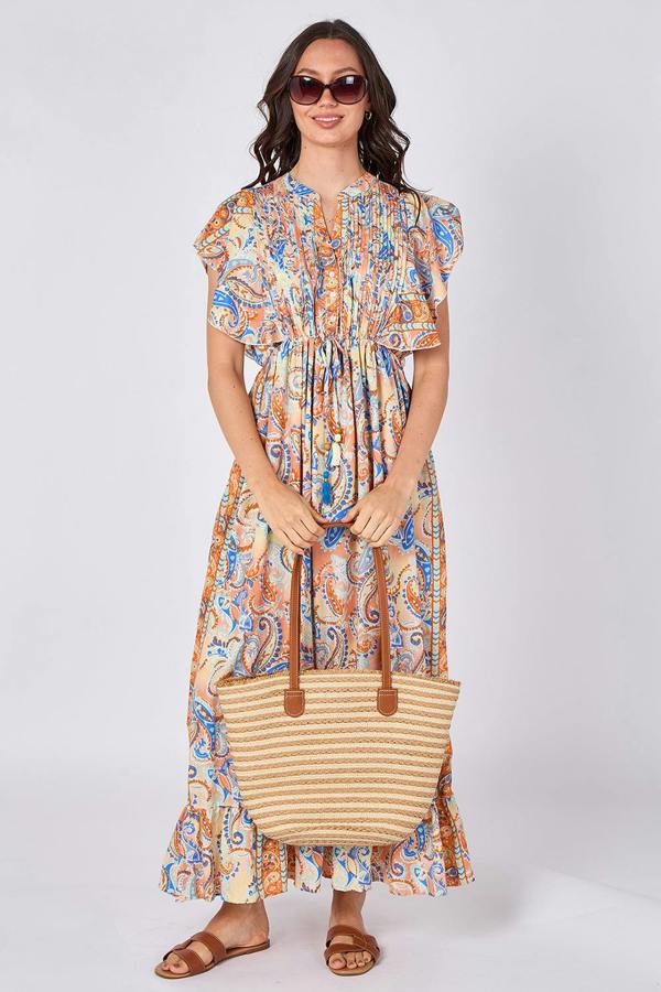 Woman wearing a patterned dress holding a striped bag on a white background