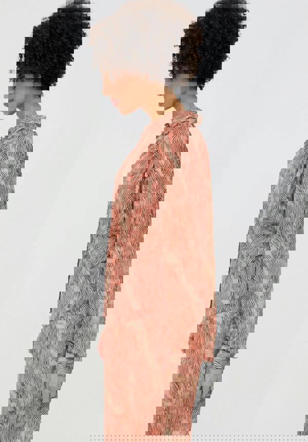 Woman wearing a patterned outfit on a plain background