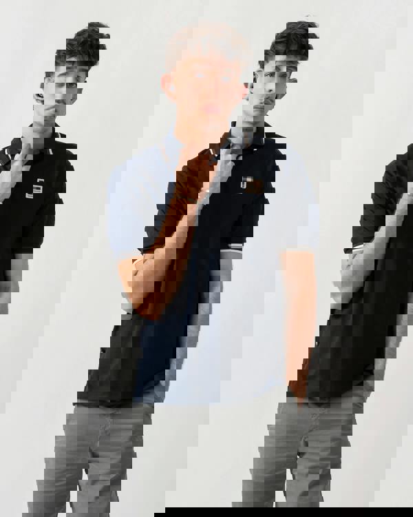 studio shot of a model wearing an Aquascutum Mens Stretch Piquet Tipped Badge Polo Shirt in Navy 11