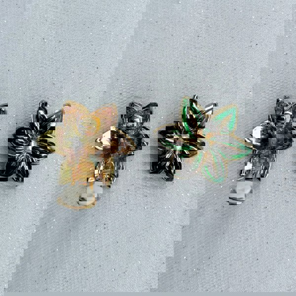 Green clip-on earrings, floral design, glossy enamel petals, gold-tone detailing, central pearl accent, bold vintage-inspired accessory
