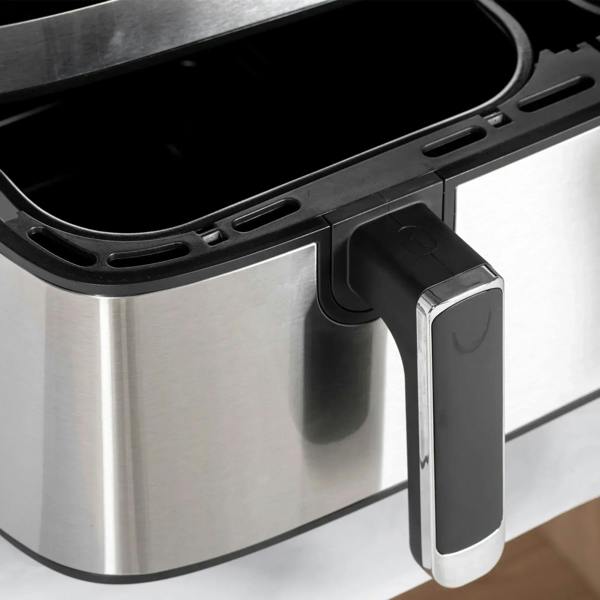 Removable fry basket with black handle insert on a stainless steel air fryer