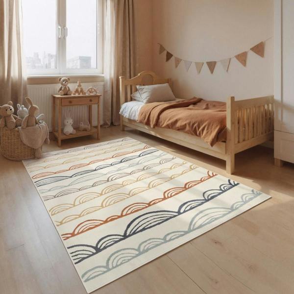 Children's bedroom with a patterned rug, bed, and toys.