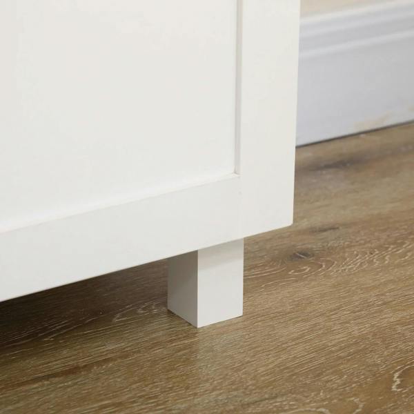 White cabinet side panel and base legs on a floor; clean corner detail