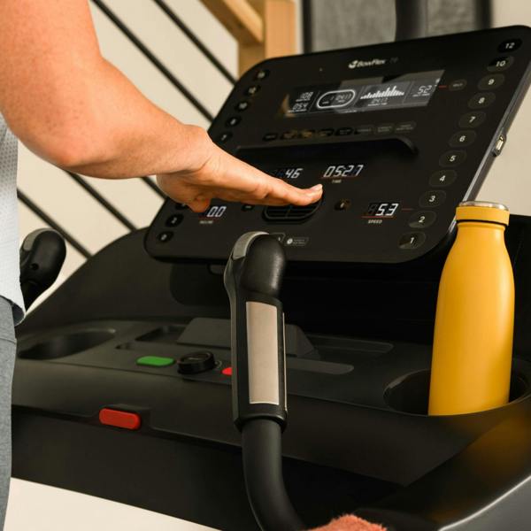 Hand using the quick controls on the BowFlex T6 treadmill console.
