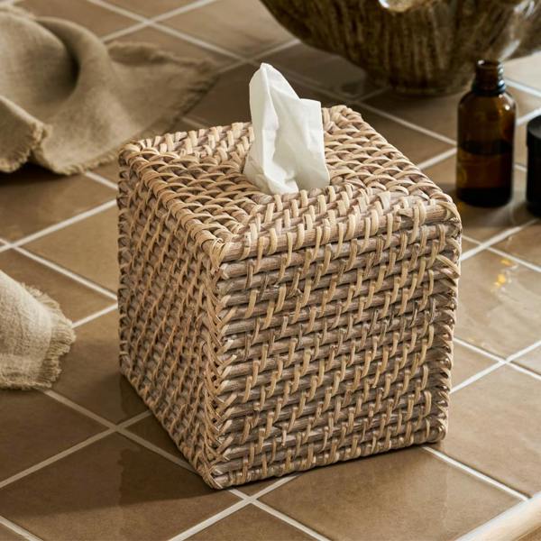 Square whitewash rattan tissue box cover styled on a tiled bathroom counter.