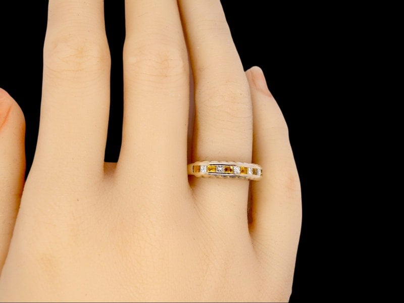 A yellow sapphire and diamond eternity ring finger view